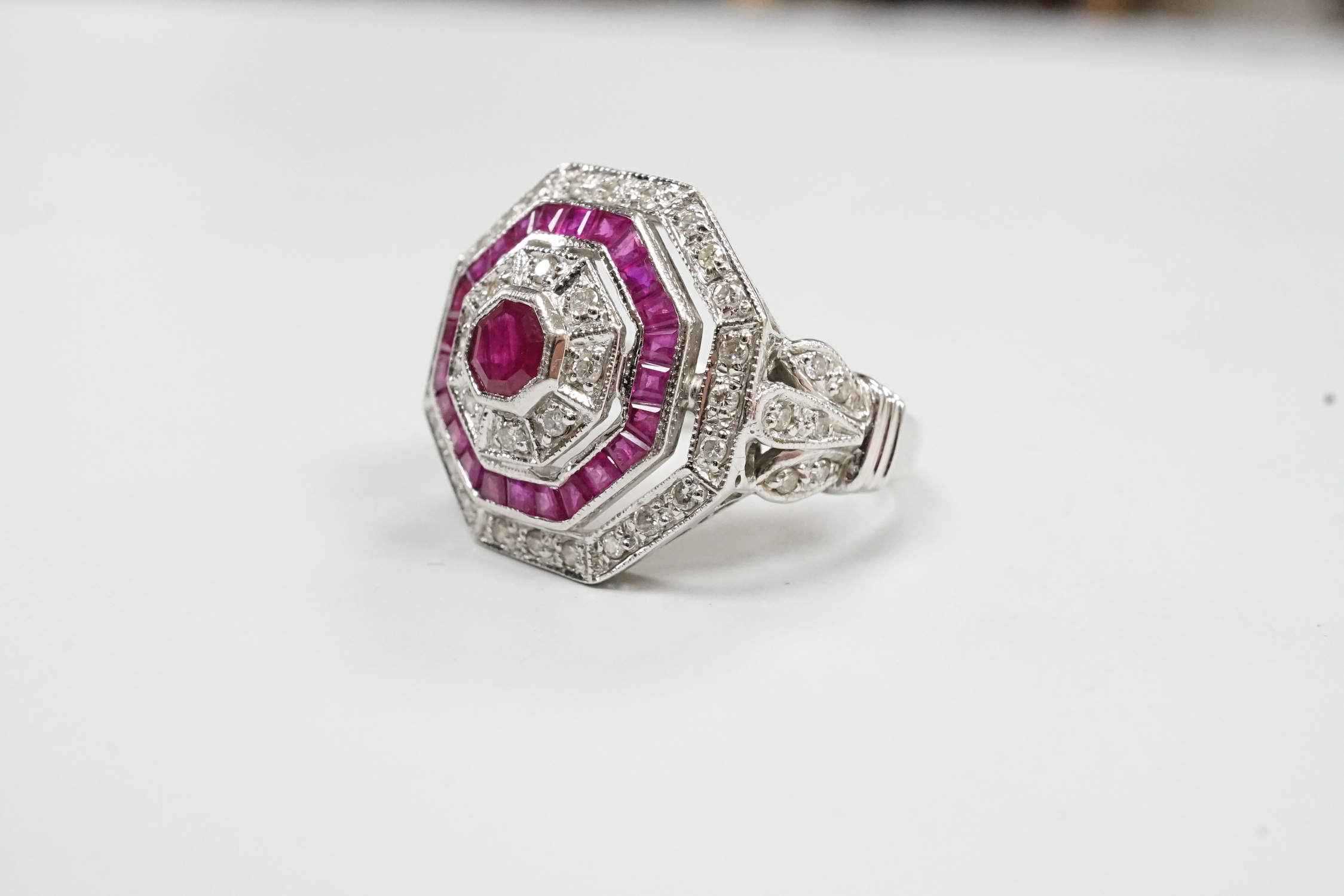 A mid to late 20th century 18ct white gold, ruby and diamond set octagonal cluster target ring, size N/O, gross weight 7.1 grams.